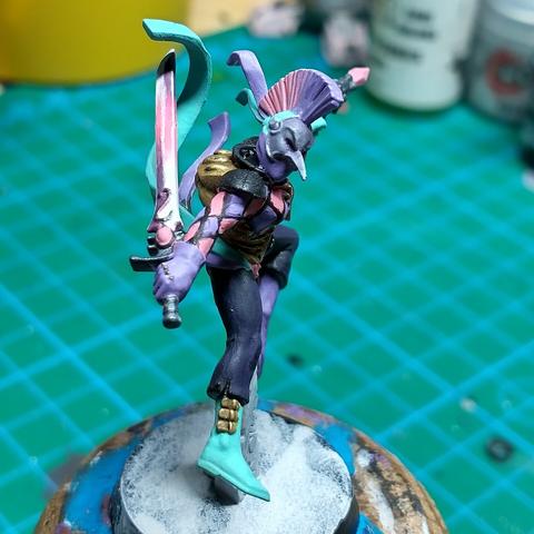 Partially painted miniature aeldari harlequin for Warhammer 40k, side view
