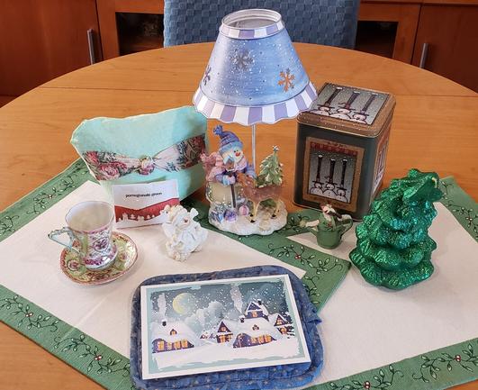 A tea tableau in pale greens, blues, and white, with a sparkling forest scene of deer, birds, and snowmen, and an antique pink & green demitasse. The tea is Pomegranate Green.