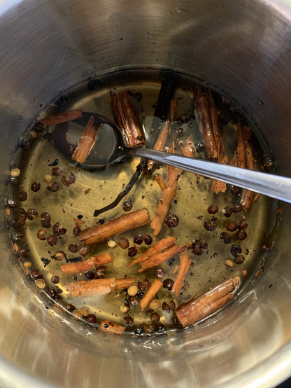 Stainless steel pan with 1:1 water and sugar syrup, broken cinnamon stick, half an open vanilla bean, and teaspoon slightly mashed Szechuan peppercorns.