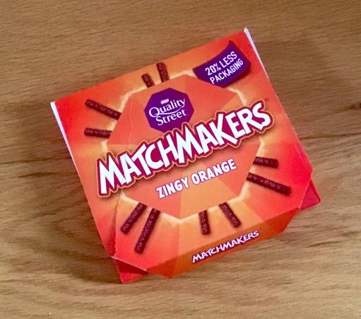 Box of orange NestlΓ© Matchmakers with a claim of 20% less packaging.