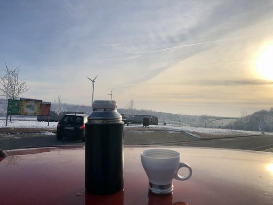 Thermoskanne mit Tasse auf rotem Autodach
