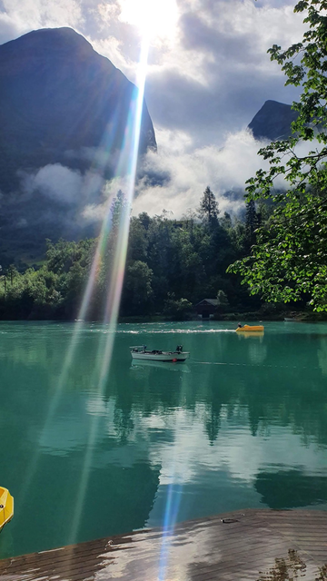A greenly coloured lake with small boats