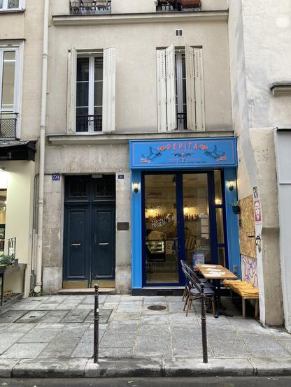 Small blue-painted restaurant tucked in the corner of a cobblestone Paris sidestreet has the phrase “vamos Argentina!” written in the window.