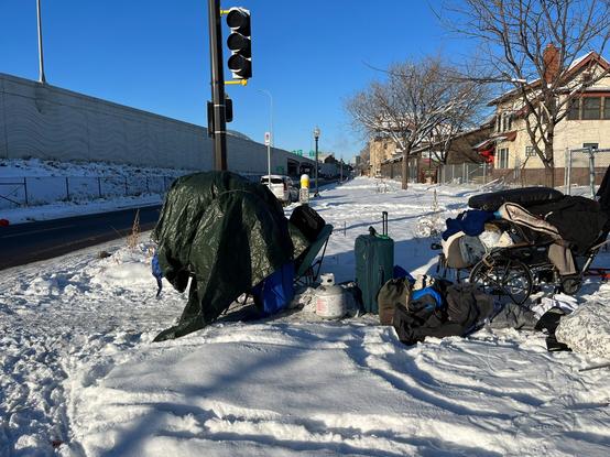 Tents, sleeping bags, chairs and other belonging along with propane tanks are discarded on a sidewalk after a homeless encampment was destroyed in -5F/-21C weather four days before Christmas