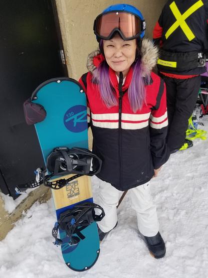 Standing with blue rental snowboard, in my Winter gear.