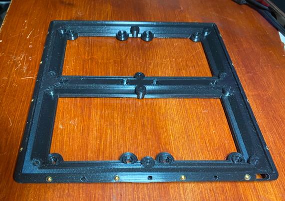Black plastic 3D printed frame with gold metal  balls embedded in the edges