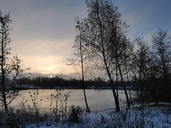 A frosty morning sunrise over a frozen pond in Cambridge, England