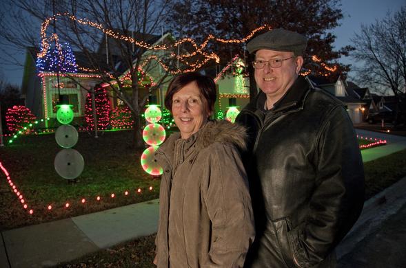 Mary Ann and Gary Martin in front of an animated Christmas light display at their home in Lawrence, Kansas.