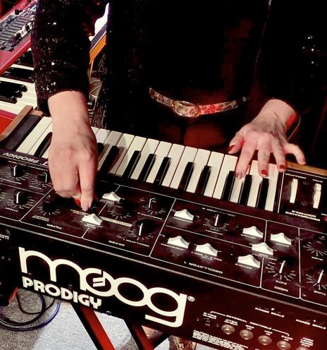 Close-up of Victoria Reyes’ hands playing a Moog Prodigy.