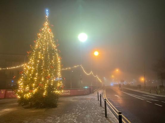 It is dark (pre-sunrise). A large Xmas tree is visible in the foreground (left) - the lights are somewhat diffused by the fog. To the right, the road over Wolfe Tone bridge disappears into the fog - only streetlights and Xmas lights are visible. In the middle of the road, a man - black in silhouette - takes a step to cross the street. My own humble nod to Henri Cartier-Bresson - the 'decisive moment'