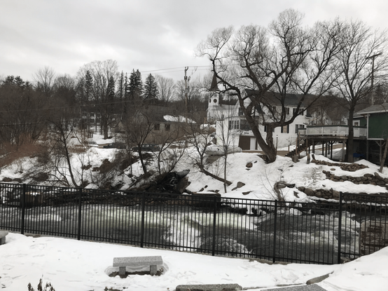 White church in background, river in foreground, snow