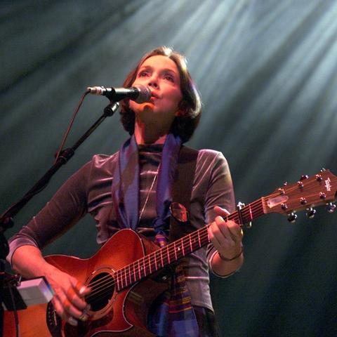 Nanci Griffith is playing guitar & singing.