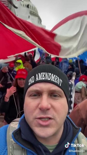 A still from a TikTok video filmed from the steps at the NW plaza of the Capitol with the Capitol dome in the background, showing a woman in the background who I believe to be Chaya Raichik