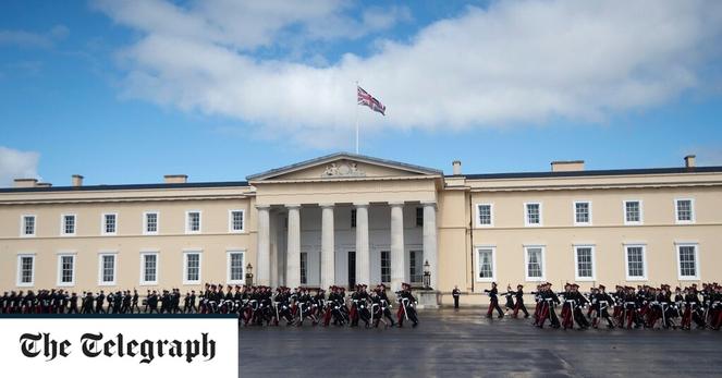 Sandhurst pictured with cadets marching on a wet parade ground in front of the building