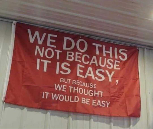 A banner that says “We do this not because it is easy, but because we thought it would be easy”