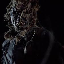 Ragged scarecrow with a decayed skulled wrapped in a tattered burlap sack.