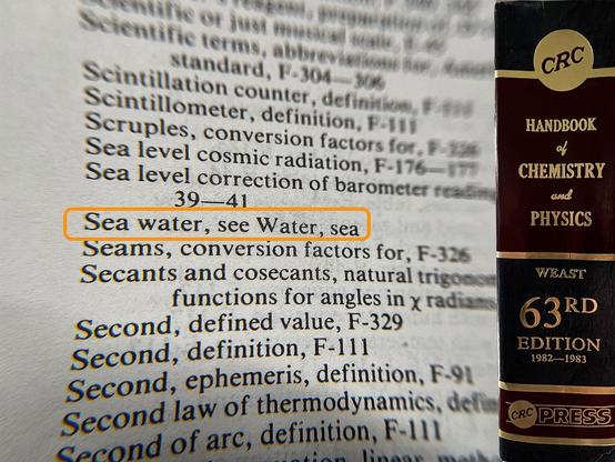 Photo of a page from a reference book highlighting an index entry that reads, "Sea water, see Water, sea." At the far right edge of the page an image of the spine of the book is superimposed reading "CRC Handbook of Chemistry and Physics — 63rd Edition 1982-1983 — CRC Press"