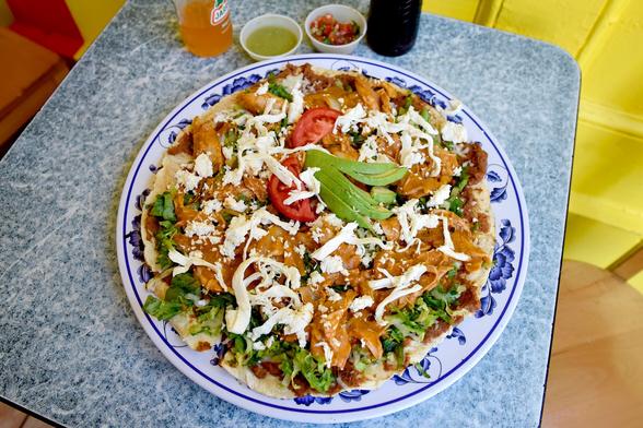 "The cashier described it as a large tostada and it instantly brought to mind my mother’s tostada, one of her specialties." A tlayuda from La Oaxaqueña, on Mission Street, in San Francisco.