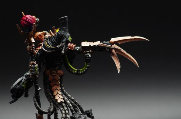 An imposing figure robed in black. They are covered in strange machinery and plumbing, some of which grows an acrid green. A gauntleted hand with long metal talons stretches out to the distance where they gaze with determination. In their other hand, they wield an alien scepter that contains a swirling field of magenta energy.