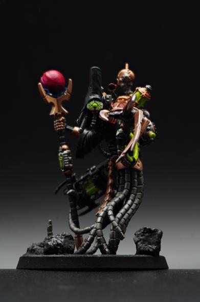 A darkly robbed figure points towards you, gazing upon you with an inscrutable array of green glowing eyes. Their figure is obscure by machinery, both familiar ad alien, and various cables. In their opposing hand, they wield a scepter adorned with a magenta sphere of glowing energy.