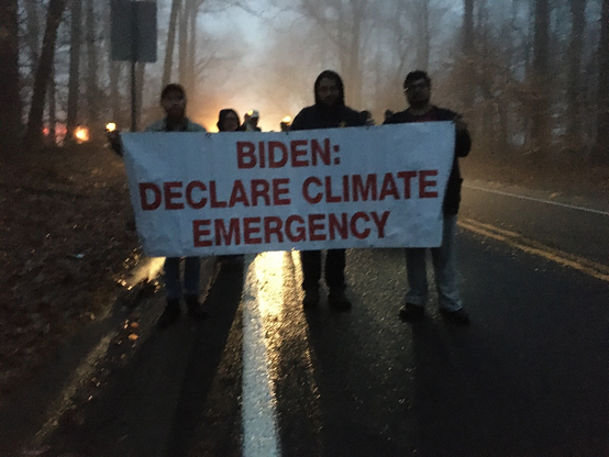 Occupy Biden Activists Carrying ‘Biden: Declare Climate Emergency’ on a foggy and rainy Barley Road walking to Joe Biden’s home (he chose to ring in the new year by flying down to St. Croix)