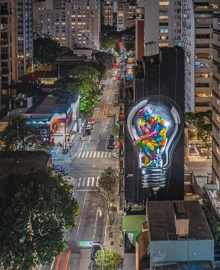 Streetartwall. On a huge house wall in São Paulo is a painting 30 meters high and 7 meters wide. It is dedicated to the theme "Corona Pandemic". It shows in bright colors the image of the famous sculpture "The Thinker" by the French sculptor Auguste Rodin. The figure, lost in thought, sits in a colorful light bulb. The background is black.
Eduardo Kobra: "In the darkness it is important to be a light for others and to make a difference".