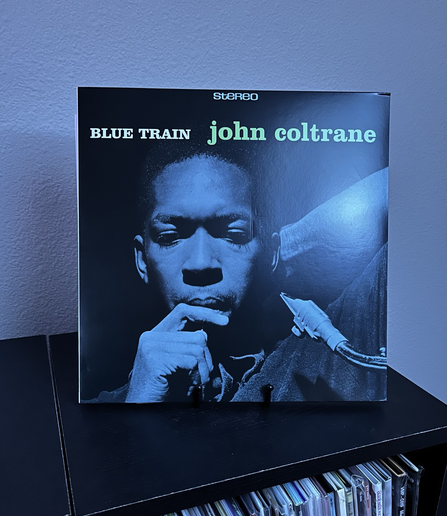 Picture of album cover of John Coltrane’s Blue Train. John is looking thoughtfully yet below the camera in a portrait of John with blue tint