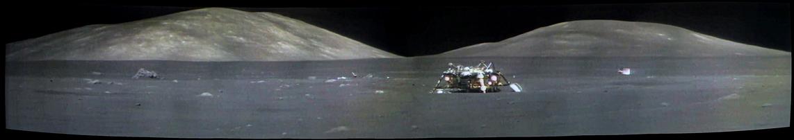 A grey lunar landscape with a lunar module descent stage and some shiny debris scattered around