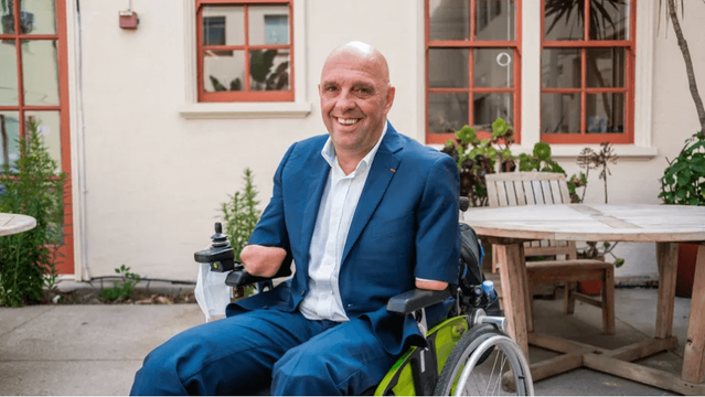 Photo de Philippe Croizon très souriant assis dans son fauteuil