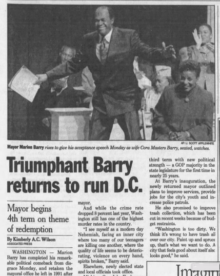 Mayor Marlon Barry rises to give his acceptance speech Monday as wife Cora Masters Barry, seated, watches. At Barry’s inauguration, the mayor promised to improve services, provide jobs for the city's youth and increase police patrols. He also promised to improve trash collection.