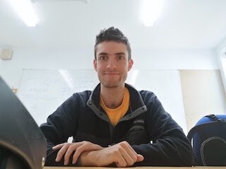 A picture of Hugo Paquet, looking forward at the camera while sitting at a desk.