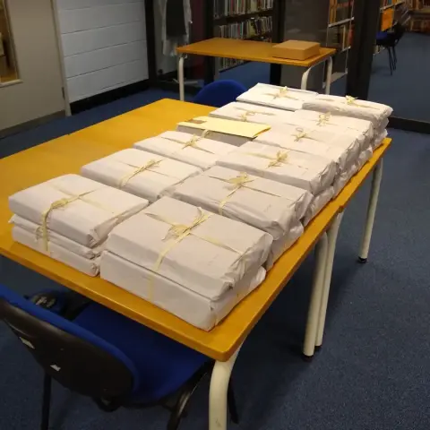 A table full of order books for machine tools manufactured by Craven Brothers Ltd. The volumes have been wrapped in acid free tissue and tied with unbleached archival tape.