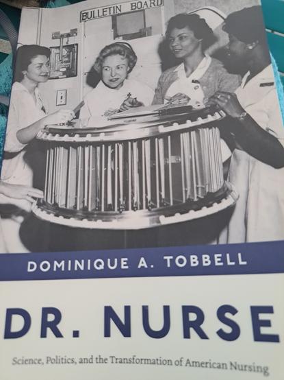 Book cover which features an old picture of nurses in dresses and caps around a rotating device used to clip boards with medical records.