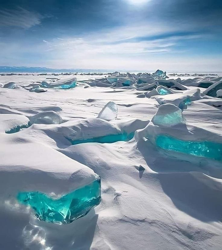 Lake Baikal in Siberia, Russia covered in snow and gorgeous turquoise ice.