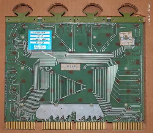 Back view of an 8k memory board from a PDP11 computer. It is covered in circuit traces, but no components. On it is a metal sticker identifying the part, an H214, as well as various other arcane numbers.