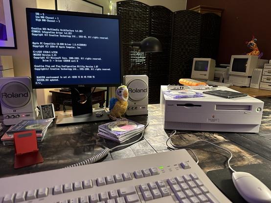 Apple Power Macintosh 4400 system on a table with a display showing a DOS screen