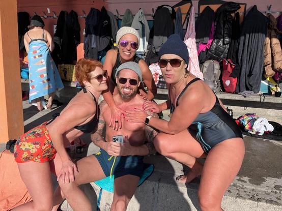 3 filles en maillot de bains qui posent leur main sur un bel homme musclé et tatoué