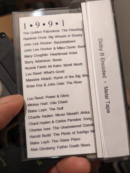 A home-made computer printed "J-Card" from an audio cassette. Black text on white paper reads:
1.9.9.1

The Golden Palominos: The Haunting 
Raintree Crow: Big Wheels in Shanty Town
John Lee Hooker: Backstabbers
John Lee Hooker & Miles Davis: Bank Robbery
Mary Coughlin: Heartbreak Hotel
Barry Adamson: Boots
Nusrat Fateh Ali Kahn: Mustt Mustt
Massive Attack: Hymn of the Big Wheel
Lou Reed: What's Good
Brian Eno & John Cale: The River

Lou Reed: Power & Glory
Mickey Hart: Udu Chant
Blake Leyh: The Gulf
Charlie Haden: Nkosi Sikelel'i Afrika
Charlie Haden & Carlos Paredes: Song For Che
Charles Ives: The Unanswered Question
Harold Budd: The Photo of Santigo McKinn
Blake Leyh: The Glass Piano
Alan Ginsberg: Father Death Blues

Dolby B Encoded  Metal Tape