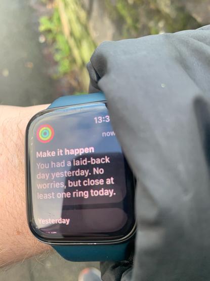 A notification from an Apple Watch. The screen reads: Make it happen. You had a laid back day yesterday. No worries but close at least one ring today.