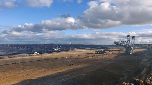 Largen open pit mine with an excavator on the right side