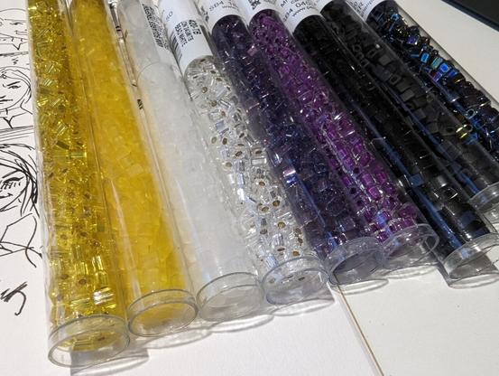Square-shaped glass beads in nonbinary pride colors, ready to be used.