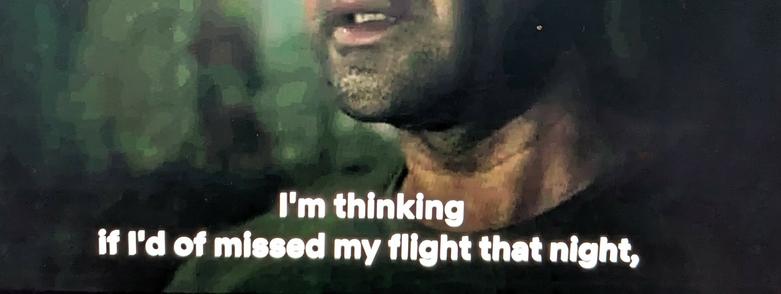 A section of a screenshot of a TV show with a closeup of a man and the subtitles "I'm thinking if I'd of missed my flight that night".