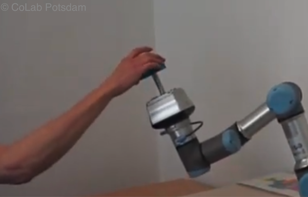 human arm receiving something from a robot arm