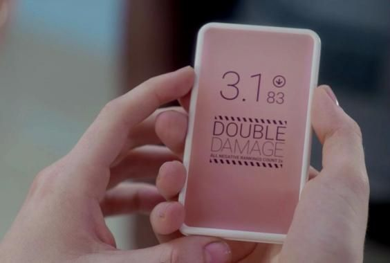 Screenshot from the episode "Nosedive" of BLACK MIRROR, featuring a device resembling a smartphone on which the display reads "3.1 ↓ DOUBLE DAMAGE", in reference to a life-wide Uber-style rating, or social credit score, that is the episode's premise.