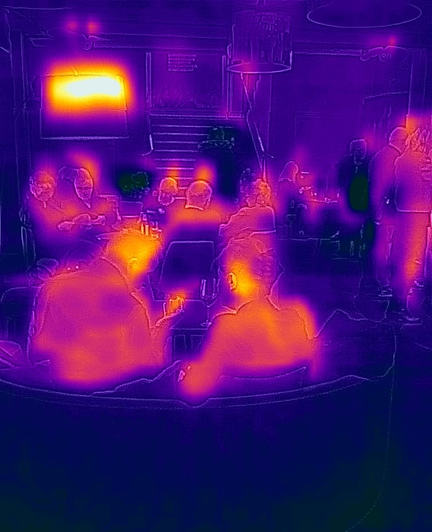 Image of people in a lobby, taken with a thermal camera capturing infra red radation.