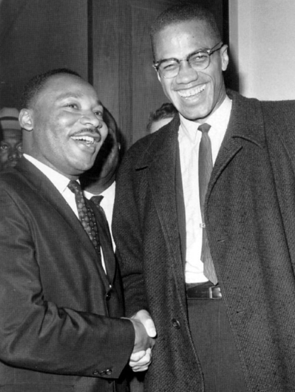 Dr. Martin Luther King Jr and Malcolm X smiling in a black and white photo