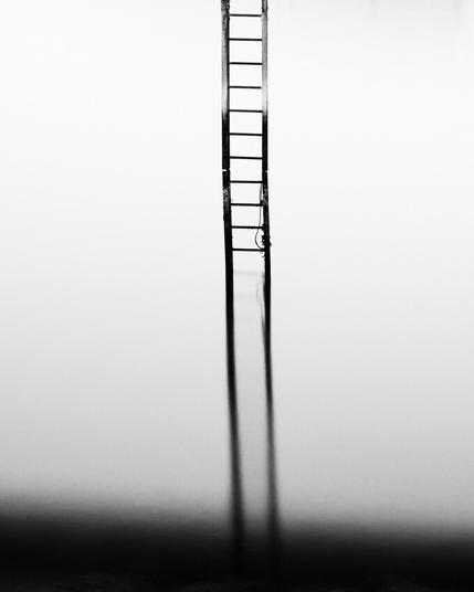 A ladder reflected in still water, fading to darkness below .