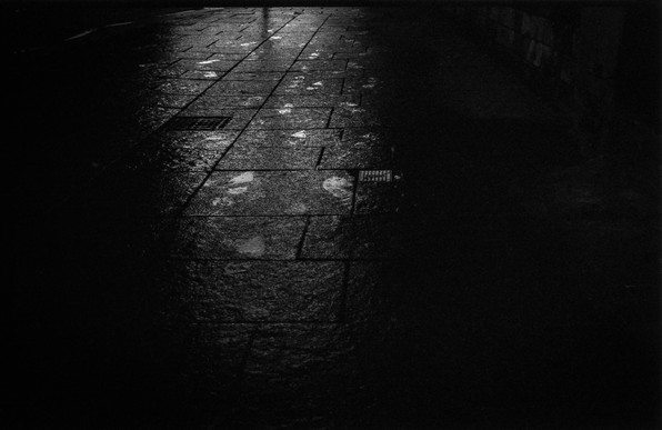 Wet footprints on a street path. Dark and atmospheric.