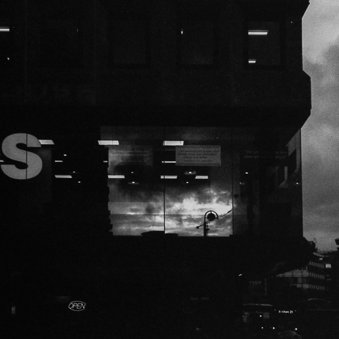 Dark scene showing a street light reflected in a window