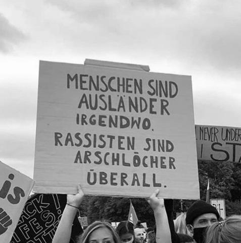 Demoschild: Menschen sind Ausländer. Irgendwo. Rassisten sind Arschlöcher. Überall.